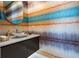Stylish powder room featuring a gold vessel sink, designer faucet, and unique wall covering at 111 Golden Gate Pt # 802Ph, Sarasota, FL 34236