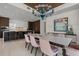 Open-concept dining area with a modern chandelier that connects to a sleek, bar-style kitchen with seating at 111 Golden Gate Pt # 802Ph, Sarasota, FL 34236