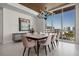 Elegant dining room with a modern chandelier, statement art, and panoramic city views through large windows at 111 Golden Gate Pt # 802Ph, Sarasota, FL 34236