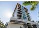 Low angle view of the building's entrance highlighting its modern architectural design and signage at 111 Golden Gate Pt # 802Ph, Sarasota, FL 34236