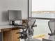 Bright home office featuring sleek desk, ergonomic chair, and stunning water views through large windows at 111 Golden Gate Pt # 802Ph, Sarasota, FL 34236