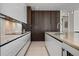 Sleek kitchen featuring white cabinetry, marble countertops, and modern stainless steel appliances at 111 Golden Gate Pt # 802Ph, Sarasota, FL 34236