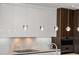 Modern kitchen pendant lighting and white cabinetry create an elegant space at 111 Golden Gate Pt # 802Ph, Sarasota, FL 34236