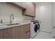 Convenient laundry room with modern washer and dryer, ample counter space, and storage cabinets at 111 Golden Gate Pt # 802Ph, Sarasota, FL 34236