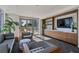 Comfortable lounge area featuring modern decor, a large window, and an entertainment center at 111 Golden Gate Pt # 802Ph, Sarasota, FL 34236