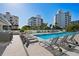 Beautiful pool area with lounge chairs and well-maintained landscaping, surrounded by luxurious buildings at 111 Golden Gate Pt # 802Ph, Sarasota, FL 34236