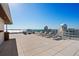 Stunning rooftop deck with panoramic water views, comfortable lounge chairs, and open-air relaxation at 111 Golden Gate Pt # 802Ph, Sarasota, FL 34236
