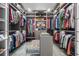 Spacious walk-in closet with ample storage, custom shelving, and seating area at 111 Golden Gate Pt # 802Ph, Sarasota, FL 34236