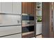Gourmet kitchen featuring stainless steel wall oven and marble backsplash at 111 Golden Gate Pt # 802Ph, Sarasota, FL 34236
