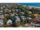 Aerial view of the property in a neighborhood close to the beach with lush surroundings and landscaping at 113 Maple Ave, Anna Maria, FL 34216
