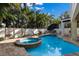 Backyard pool and jacuzzi with lounge chairs in a tropical setting at 113 Maple Ave, Anna Maria, FL 34216