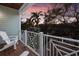 Relaxing balcony view features palm trees and colorful sunset over the neighborhood at 113 Maple Ave, Anna Maria, FL 34216