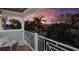 Balcony view showcases a vibrant sunset sky, palm trees, and neighborhood charm at 113 Maple Ave, Anna Maria, FL 34216