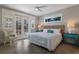 Comfortable bedroom with french doors leading to a balcony and coastal-themed decor at 113 Maple Ave, Anna Maria, FL 34216