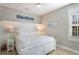 Inviting bedroom with a plush bed, coastal decor, and ample natural light from the window at 113 Maple Ave, Anna Maria, FL 34216