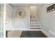 Inviting entryway with tile floors, staircase, and a decorative mirror adding a touch of style at 113 Maple Ave, Anna Maria, FL 34216