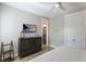 Comfortable main bedroom featuring a dresser with TV and a doorway to the ensuite bath at 113 Maple Ave, Anna Maria, FL 34216