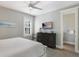 Serene main bedroom featuring tile floors, a ceiling fan, TV, and an ensuite bathroom at 113 Maple Ave, Anna Maria, FL 34216