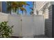 Outdoor shower space with a shower head and a white privacy fence at 113 Maple Ave, Anna Maria, FL 34216