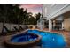Home back exterior featuring a patio area and beautiful pool with a small table and spiral staircase at 113 Maple Ave, Anna Maria, FL 34216