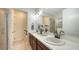 Bathroom boasts double sinks, wooden cabinets, large mirror, and a glass shower enclosure at 11847 Meadowgate Pl, Lakewood Ranch, FL 34211