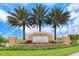 Landscaped entrance to Harmony at Lakewood Ranch with palm trees and colorful flowerbeds at 11847 Meadowgate Pl, Lakewood Ranch, FL 34211