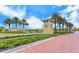 Inviting community entrance with brick paver road, guard house, and palm tree lined entrance at 11847 Meadowgate Pl, Lakewood Ranch, FL 34211