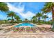 Relaxing pool area surrounded by comfortable lounge chairs and lush tropical landscaping. Palm trees and blue sky overhead at 11847 Meadowgate Pl, Lakewood Ranch, FL 34211