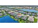 An aerial view of home showcasing pool, tile roof, lake, and surrounding community at 11913 Blue Hill Trl, Bradenton, FL 34211