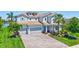 Well-maintained two-story home with three-car garage, brick driveway, and well-manicured landscaping at 11913 Blue Hill Trl, Bradenton, FL 34211