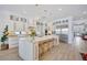 Spacious kitchen featuring white cabinets, a large island, and stainless steel refrigerator at 11913 Blue Hill Trl, Bradenton, FL 34211