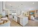 Open kitchen with island, stainless steel appliances, and view of the living area and staircase at 11913 Blue Hill Trl, Bradenton, FL 34211