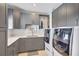 Well-organized laundry room with gray cabinetry, quartz countertops, and modern washer/dryer at 11913 Blue Hill Trl, Bradenton, FL 34211