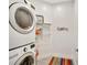 Clean laundry room with a stacked washer and dryer unit, complemented by ample shelving at 11913 Blue Hill Trl, Bradenton, FL 34211