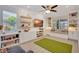 Bright living room featuring custom built-ins, modern ceiling fan, and a cozy window bench at 11913 Blue Hill Trl, Bradenton, FL 34211