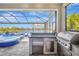 Outdoor kitchen with stainless steel appliances and bar seating, perfect for al fresco dining by the pool at 11913 Blue Hill Trl, Bradenton, FL 34211