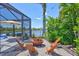Outdoor patio with screened enclosure, fire pit, and waterfront view, perfect for relaxing evenings at 11913 Blue Hill Trl, Bradenton, FL 34211