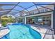 The house boasts a screened-in pool, spa, outdoor kitchen, and lounge area ideal for relaxation at 11913 Blue Hill Trl, Bradenton, FL 34211