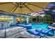 Inviting screened-in pool with spa, swim-up bar, and comfortable lounge chairs overlooking the landscaped yard at 11913 Blue Hill Trl, Bradenton, FL 34211