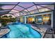 Evening view of the screened-in pool, spa, outdoor kitchen, and lounge area for relaxation at 11913 Blue Hill Trl, Bradenton, FL 34211