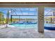 Gorgeous pool with a waterfall feature overlooking a scenic lake view in a screened lanai at 11913 Blue Hill Trl, Bradenton, FL 34211