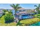 A screened-in pool and spa are surrounded by lush landscaping and a tree at 11913 Blue Hill Trl, Bradenton, FL 34211