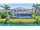 Rear exterior shot of home overlooking lake with screened-in lanai and pool at 11913 Blue Hill Trl, Bradenton, FL 34211