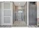 Close up of a stylish walk-in shower featuring decorative tile and gray cabinetry at 11913 Blue Hill Trl, Bradenton, FL 34211