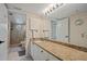 Well-maintained bathroom with ample counter space, decorative wallpaper, and a tiled shower area at 1223 Siesta Bayside Dr # 1223, Sarasota, FL 34242
