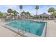 Beautiful pool with several lounge chairs and tables, tall palm trees, and buildings in the background at 1223 Siesta Bayside Dr # 1223, Sarasota, FL 34242