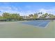 Full tennis court with green and blue surface surrounded by trees and shrubbery at 1223 Siesta Bayside Dr # 1223, Sarasota, FL 34242