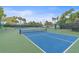 Another full tennis court with green and blue surface surrounded by trees and shrubbery at 1223 Siesta Bayside Dr # 1223, Sarasota, FL 34242