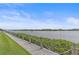 Scenic view of waterway with boats surrounded by green foliage and a rope fence along a path at 1223 Siesta Bayside Dr # 1223, Sarasota, FL 34242