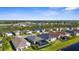 A scenic community with houses surrounding a pond, featuring landscaped yards at 12565 Ryegrass Loop, Parrish, FL 34219